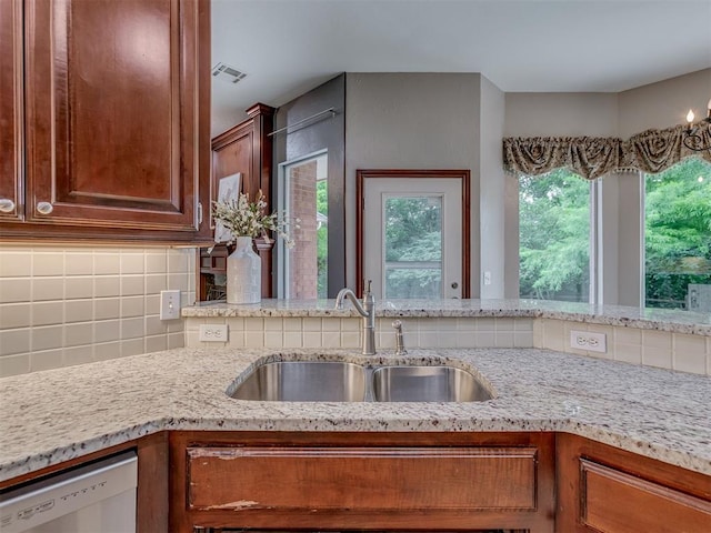 3716 Equestrian Ct, Edmond, OK 73034 - kitchen featuring white dishwasher, plenty of natural light, decorative backsplash, and light stone countertops