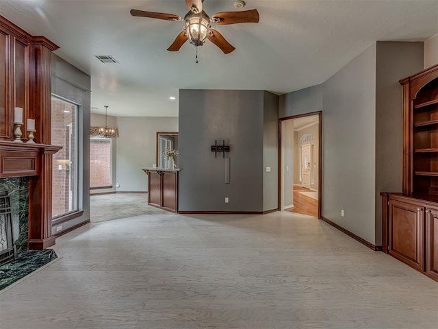3716 Equestrian Ct, Edmond, OK 73034 - unfurnished living room featuring ceiling fan, a chandelier, a high end fireplace, and light wood-style flooring