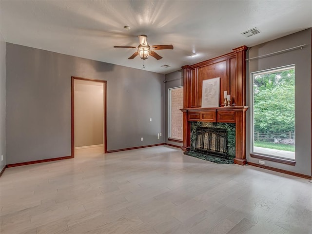 3716 Equestrian Ct, Edmond, OK 73034 - unfurnished living room featuring a ceiling fan, a premium fireplace, and light wood-style floors