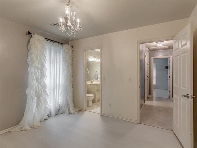 3716 Equestrian Ct, Edmond, OK 73034 - unfurnished bedroom featuring a chandelier, ensuite bathroom, and wood finished floors