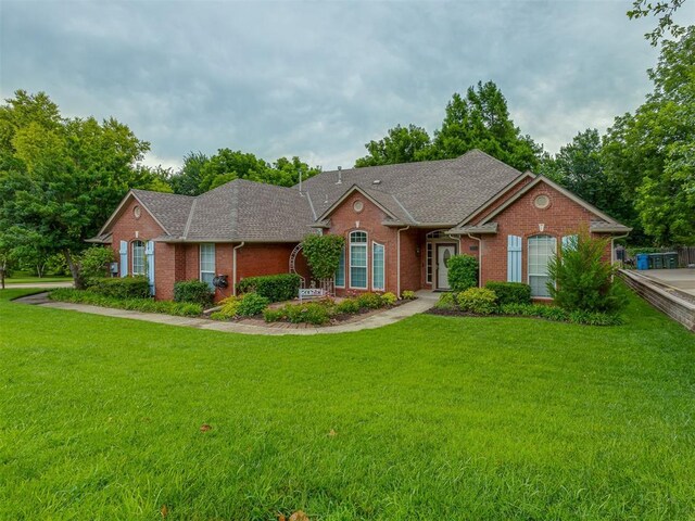 3716 Equestrian Ct, Edmond, OK 73034 - view of front of house with brick siding, a front yard, and a shingled roof