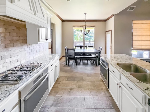 2010 Lakewood, Seminole, OK 74868 - kitchen with appliances with stainless steel finishes, tasteful backsplash, crown molding, white cabinetry, and pendant lighting