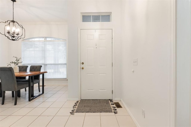 14213 Pecan Hollow Ter, Edmond, OK 73013 - entryway with a chandelier, light tile patterned flooring, and crown molding