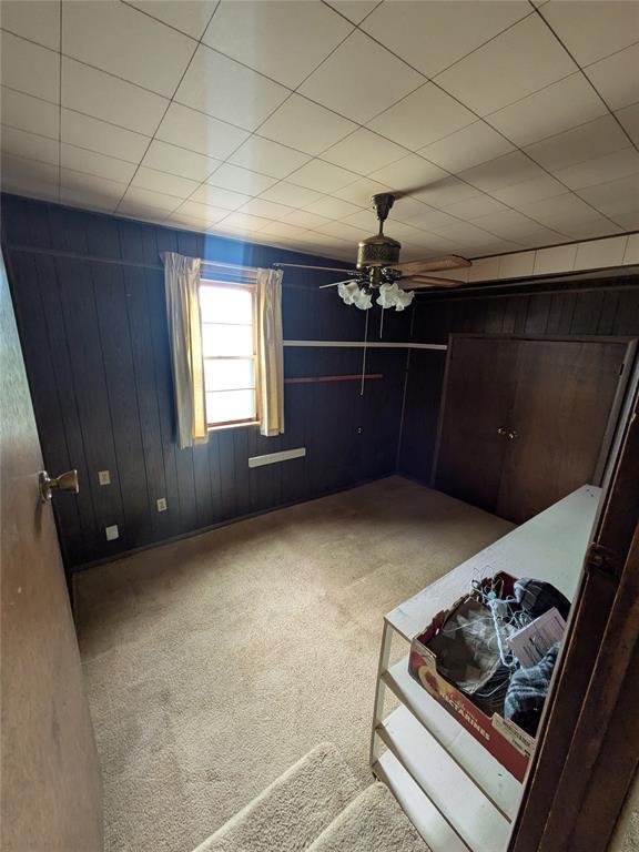 733 E Steed Dr, Midwest City, OK 73110 - unfurnished bedroom featuring carpet and wooden walls