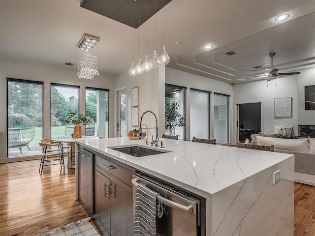 3604 Valley Creek Cir, Edmond, OK 73034 - kitchen with dishwasher, open floor plan, decorative light fixtures, light wood-style floors, and an island with sink