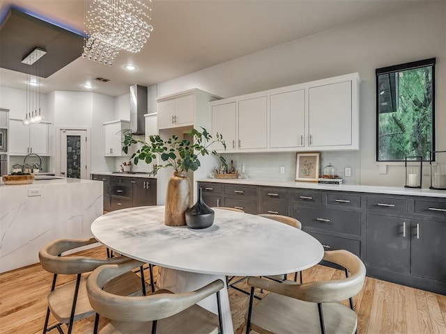 3604 Valley Creek Cir, Edmond, OK 73034 - kitchen featuring white cabinetry, ventilation hood, light wood finished floors, stainless steel appliances, and decorative light fixtures