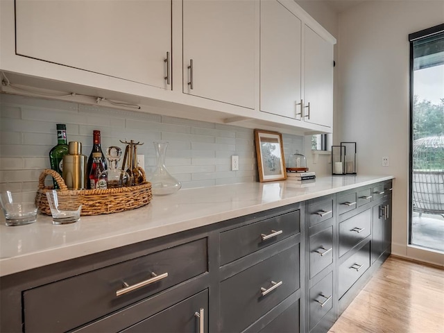 3604 Valley Creek Cir, Edmond, OK 73034 - kitchen with tasteful backsplash, light countertops, light wood-style floors, and white cabinets