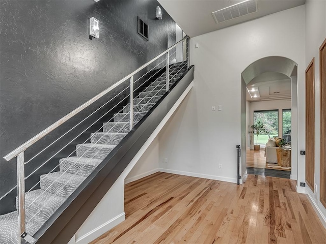 3604 Valley Creek Cir, Edmond, OK 73034 - stairway featuring arched walkways and wood finished floors