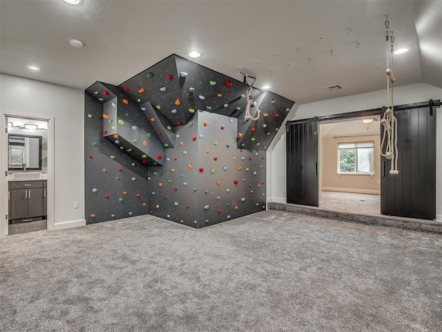 3604 Valley Creek Cir, Edmond, OK 73034 - carpeted empty room with a barn door, vaulted ceiling, recessed lighting, and a smoke detector