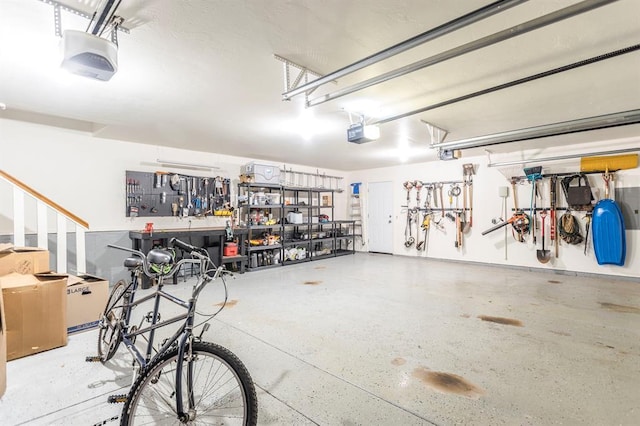 2525 Steeplechase Rd, Edmond, OK 73034 - garage featuring a garage door opener and a workshop area