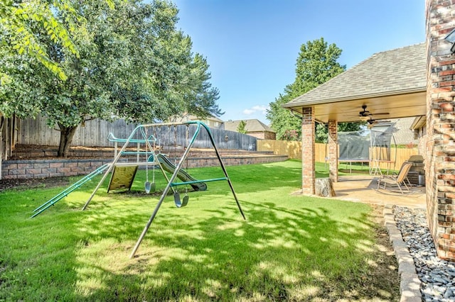 2525 Steeplechase Rd, Edmond, OK 73034 - fenced backyard featuring a trampoline, a playground, and a ceiling fan