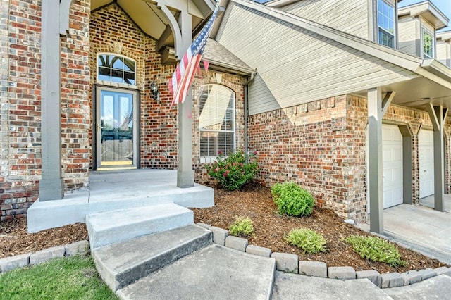 2525 Steeplechase Rd, Edmond, OK 73034 - view of exterior entry with brick siding, driveway, an attached garage, and covered porch