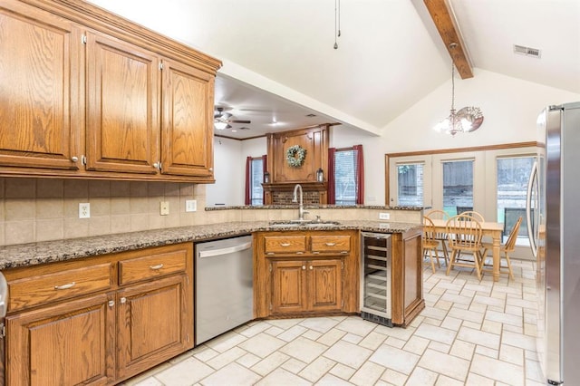 2525 Steeplechase Rd, Edmond, OK 73034 - kitchen with appliances with stainless steel finishes, beverage cooler, decorative backsplash, a peninsula, and brown cabinetry