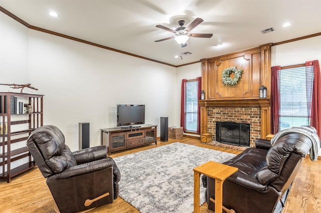 2525 Steeplechase Rd, Edmond, OK 73034 - living area with ornamental molding, a ceiling fan, healthy amount of natural light, a brick fireplace, and light wood-style floors