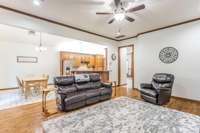 2525 Steeplechase Rd, Edmond, OK 73034 - living area featuring a ceiling fan, light wood-style floors, crown molding, recessed lighting, and a chandelier