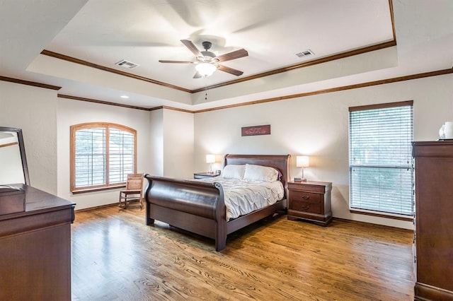2525 Steeplechase Rd, Edmond, OK 73034 - bedroom featuring a tray ceiling, crown molding, wood finished floors, and a ceiling fan