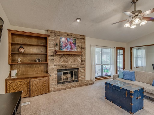3213 Creekwood Ct, Norman, OK 73072 - living room with carpet flooring, ceiling fan, a textured ceiling, lofted ceiling, and a brick fireplace