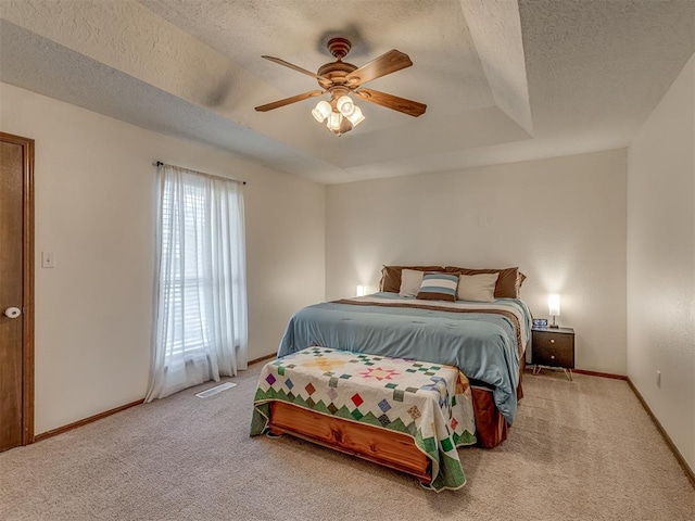 3213 Creekwood Ct, Norman, OK 73072 - bedroom featuring carpet flooring, a tray ceiling, a textured ceiling, and a ceiling fan
