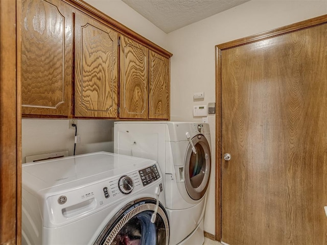 3213 Creekwood Ct, Norman, OK 73072 - washroom featuring separate washer and dryer, cabinet space, and a textured ceiling