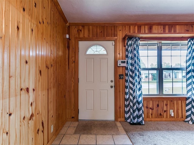 1016 Maple Ave, Yukon, OK 73099 - foyer entrance with wooden walls, light tile patterned flooring, and a textured ceiling