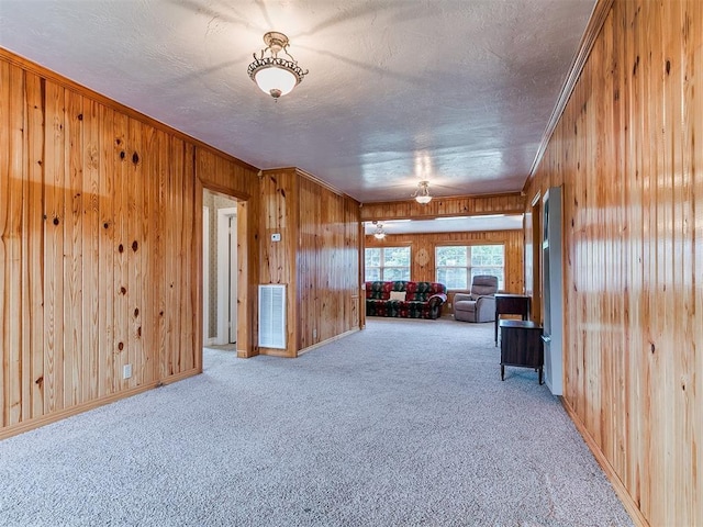 1016 Maple Ave, Yukon, OK 73099 - unfurnished room featuring wood walls, ornamental molding, carpet floors, and a textured ceiling