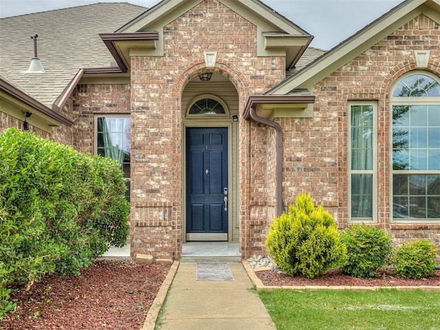 18501 El Greco Dr, Edmond, OK 73012 - view of exterior entry featuring brick siding and roof with shingles