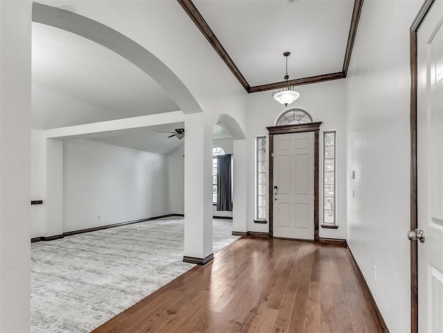 18501 El Greco Dr, Edmond, OK 73012 - foyer entrance with crown molding, a ceiling fan, hardwood / wood-style flooring, and arched walkways