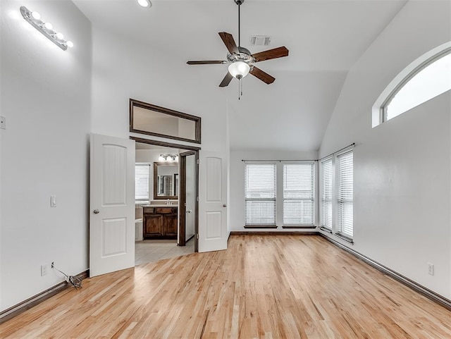 18501 El Greco Dr, Edmond, OK 73012 - unfurnished living room with high vaulted ceiling, plenty of natural light, light wood-type flooring, and a ceiling fan
