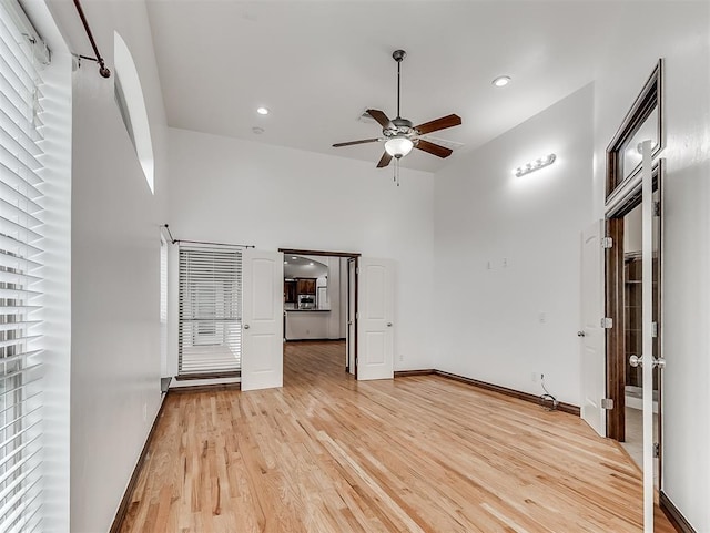 18501 El Greco Dr, Edmond, OK 73012 - empty room featuring a ceiling fan, a high ceiling, light wood-style flooring, and recessed lighting