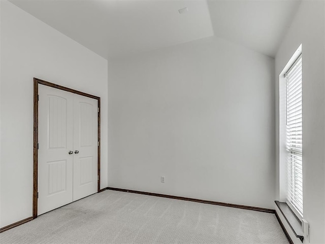 18501 El Greco Dr, Edmond, OK 73012 - unfurnished bedroom featuring light colored carpet, vaulted ceiling, and a closet