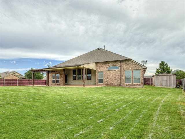 18501 El Greco Dr, Edmond, OK 73012 - back of house featuring a fenced backyard, a storage unit, roof with shingles, a patio area, and brick siding