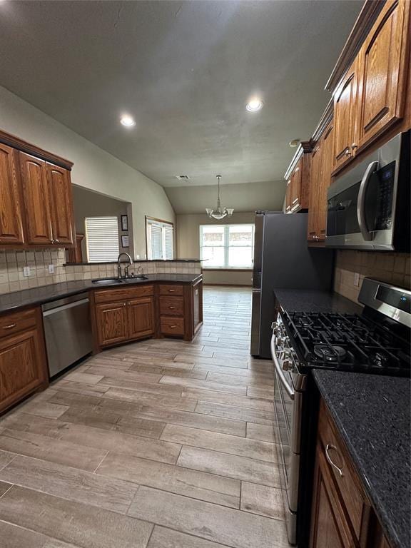 712 N Cherokee Way, Mustang, OK 73064 - kitchen featuring appliances with stainless steel finishes, a chandelier, light wood finished floors, tasteful backsplash, and recessed lighting