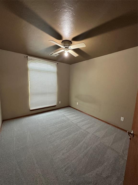 712 N Cherokee Way, Mustang, OK 73064 - unfurnished room featuring light colored carpet and ceiling fan