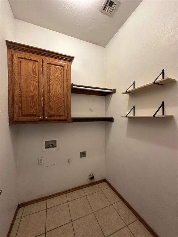 712 N Cherokee Way, Mustang, OK 73064 - laundry room featuring cabinet space, gas dryer hookup, hookup for a washing machine, light tile patterned floors, and electric dryer hookup