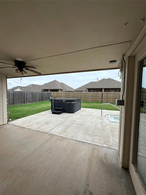 712 N Cherokee Way, Mustang, OK 73064 - fenced backyard featuring a hot tub, a patio, and ceiling fan
