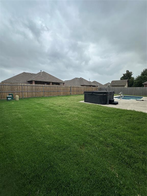 712 N Cherokee Way, Mustang, OK 73064 - fenced backyard with a hot tub