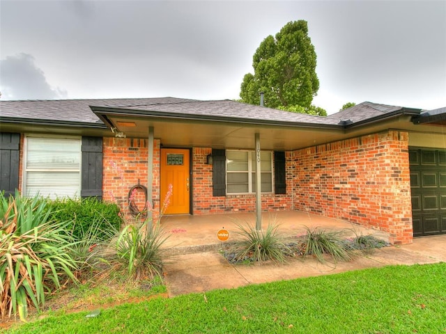 1040 Mabel C Fry Blvd, Yukon, OK 73099 - view of exterior entry featuring brick siding, an attached garage, and a porch