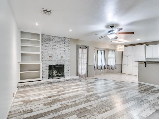 1040 Mabel C Fry Blvd, Yukon, OK 73099 - unfurnished living room featuring built in features, ceiling fan, light wood-style flooring, a fireplace, and recessed lighting