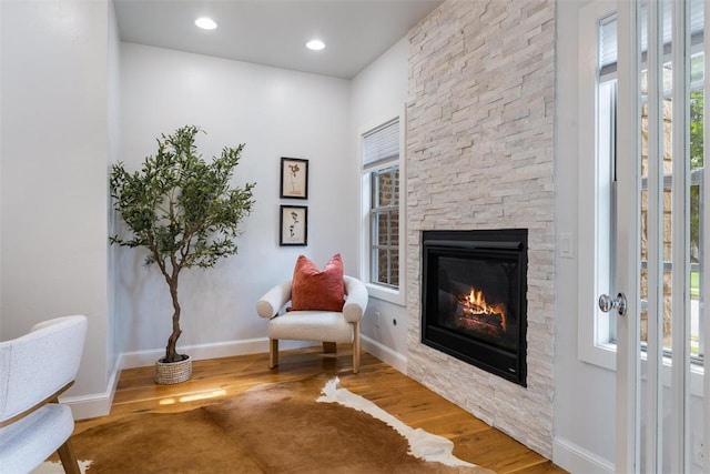 1517 Station St, Edmond, OK 73034 - sitting room featuring wood finished floors, a stone fireplace, and healthy amount of natural light