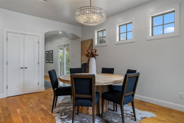 1517 Station St, Edmond, OK 73034 - dining room with arched walkways, light wood-type flooring, and a chandelier