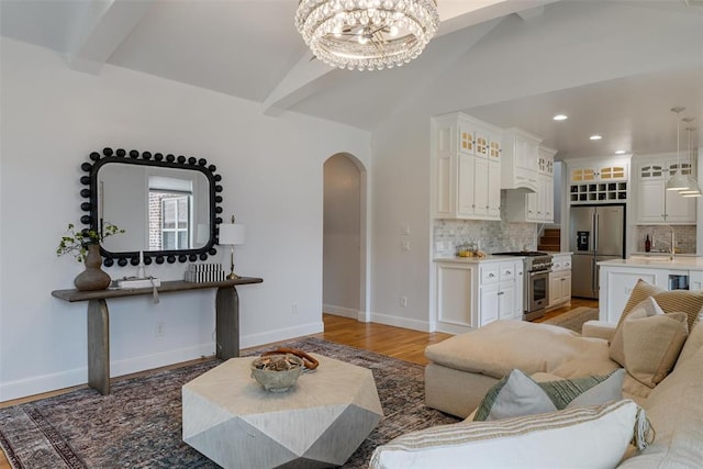 1517 Station St, Edmond, OK 73034 - living area with arched walkways, a chandelier, recessed lighting, and light wood finished floors
