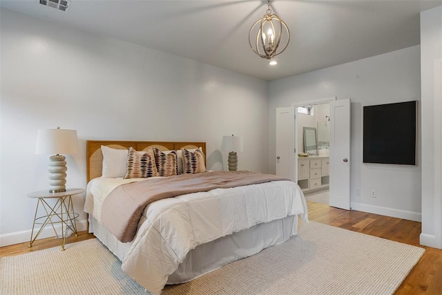 1517 Station St, Edmond, OK 73034 - bedroom featuring wood finished floors, a chandelier, and ensuite bathroom