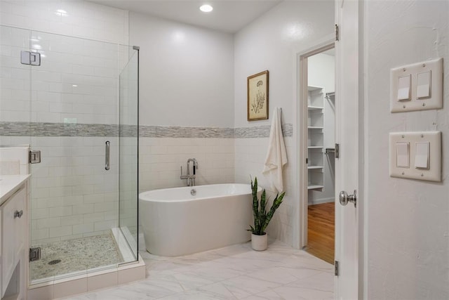 1517 Station St, Edmond, OK 73034 - bathroom featuring a stall shower, a walk in closet, a soaking tub, vanity, and marble finish flooring