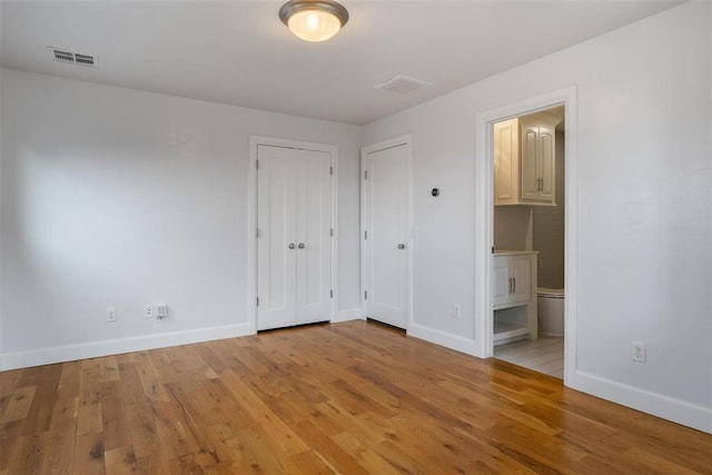 1517 Station St, Edmond, OK 73034 - unfurnished bedroom with light wood-type flooring and connected bathroom