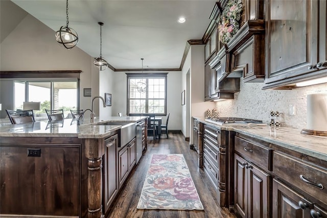 15936 SW 12th St, Yukon, OK 73099 - kitchen featuring dark wood finished floors, a kitchen island with sink, light stone counters, dark brown cabinetry, and crown molding