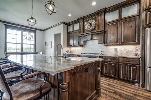 15936 SW 12th St, Yukon, OK 73099 - kitchen featuring ornamental molding, light stone countertops, a breakfast bar, tasteful backsplash, and dark wood-type flooring