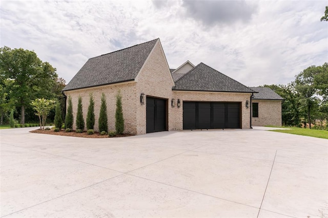 3005 Bee Hive Way, Jones, OK 73049 - view of home's exterior featuring a garage, concrete driveway, brick siding, and roof with shingles