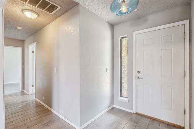 1909 Magnolia Ln, Edmond, OK 73013 - foyer entrance featuring light wood-style floors and a textured ceiling