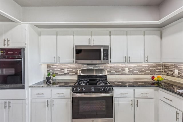 1909 Magnolia Ln, Edmond, OK 73013 - kitchen featuring stainless steel appliances, white cabinetry, decorative backsplash, and dark stone countertops