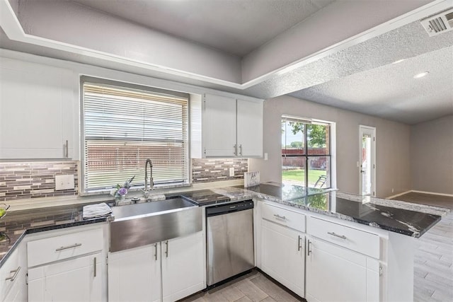 1909 Magnolia Ln, Edmond, OK 73013 - kitchen featuring dishwasher, a peninsula, white cabinets, and a textured ceiling